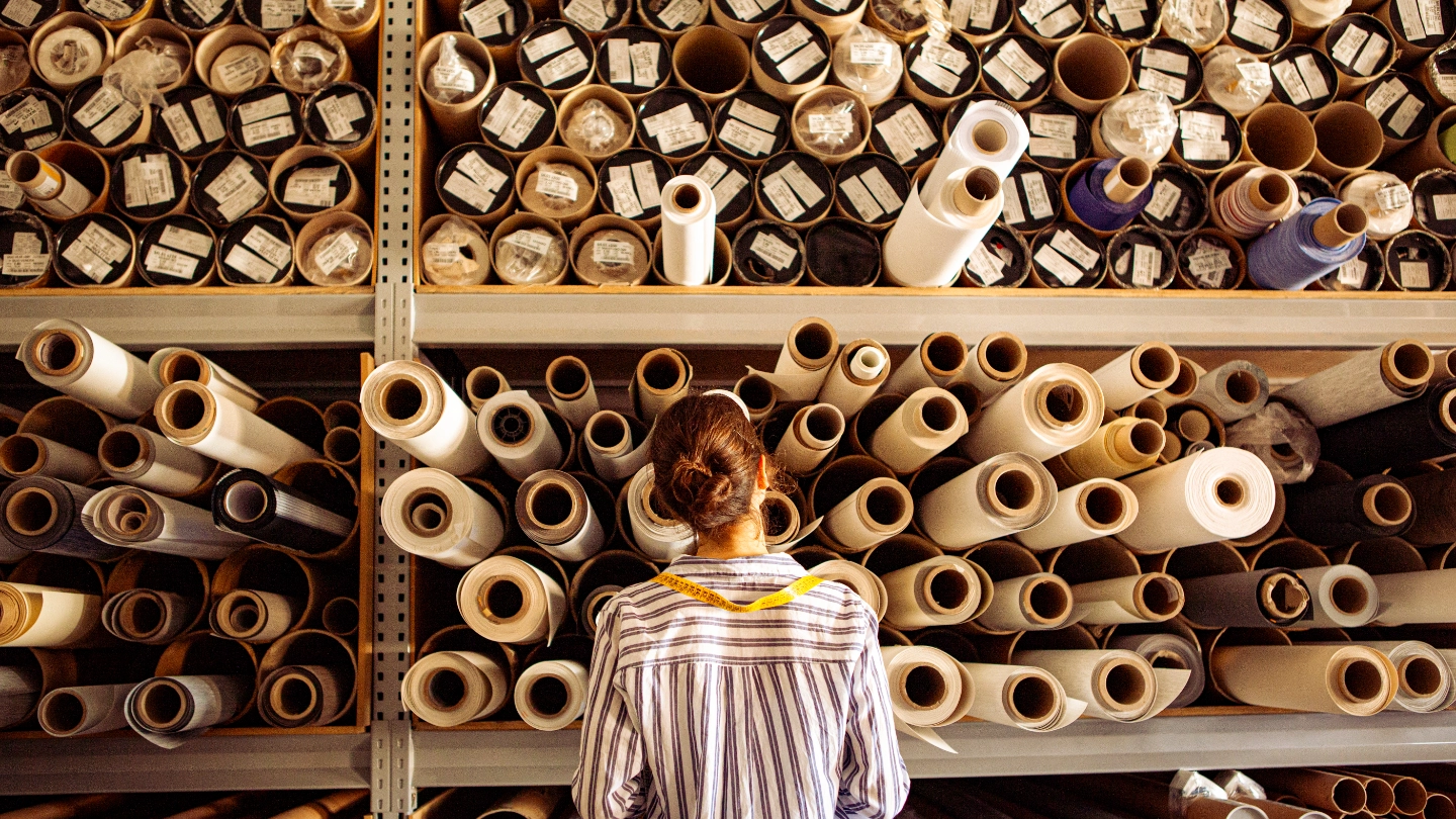 Female textile worker examining reels of fabric Female textile worker examining reels of fabric